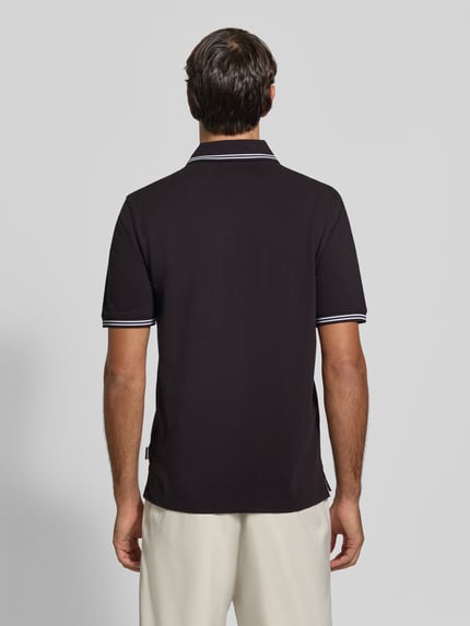 Männermodel trägt Slim Fit Poloshirt mit Label-Stitching von bugatti aus reiner Baumwolle, dunkle Farbe, glatte Textur, Ganzkörperansicht Rückansicht.