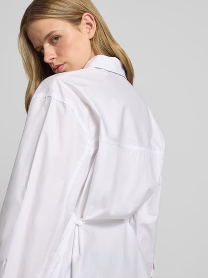 Vrouwenmodel draagt oversized fit dames overhemdblouse van puur katoen met borstzak, model 'Demi' van Topshop, detailopname rugaanzicht.