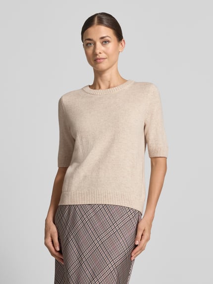 Frauenmodel trägt Pullover aus Baumwoll-Mix in Feinstrick-Optik von COMMA, beige Farbe, gerippte Abschlüsse, Nahaufnahme Oberkörper.