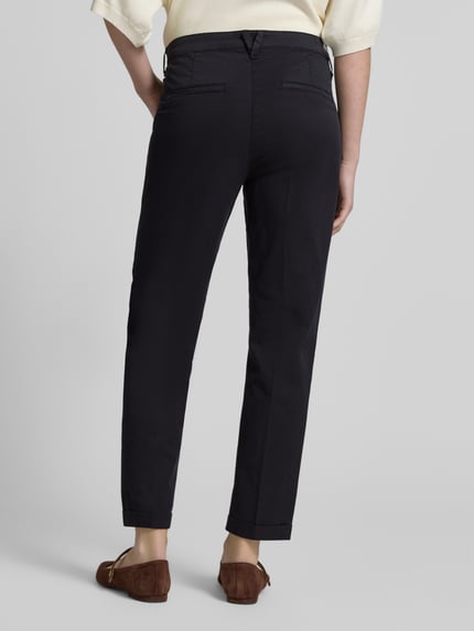 Frauenmodel trägt Chino mit Eingrifftaschen von MAC in Dunkelblau, Baumwoll-Elasthan-Mix, Regular Fit, Gesäßtaschen, Ganzkörperansicht Rückansicht.