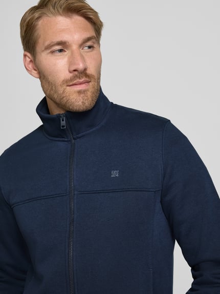 Männermodel trägt Regular Fit Sweatjacke aus Baumwoll-Mix von s.Oliver RED LABEL in Dunkelblau, Nahaufnahme Oberkörper.