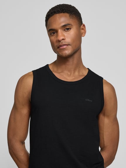Männermodel trägt Regular Fit Tank Top aus reiner Baumwolle von s.Oliver RED LABEL, Optik: Unifarben, Label-Print, Nahaufnahme Oberkörper.