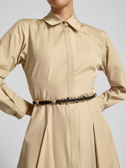 Frauenmodel trägt Regular Fit Blusenkleid aus reiner Baumwolle Modell 'STAFFETTO' von Max Mara in Optik: Unifarben, Midi-Länge, Hemdblusenkragen, Teilungsnähte, Kellerfalten, gelegte Falten, verdeckte Knopfleiste, Gürtel, Ärmelform: Langarm, Ärmelabschluss: Manschette, glatte Textur, Nahaufnahme Oberkörper.