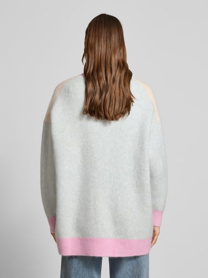 Frauenmodel trägt Cardigan aus Woll-Mix mit V-Ausschnitt und Knopfleiste von Herzensangelegenheit, pastellfarben, Relaxed Fit, Ganzkörperansicht Rückansicht.
