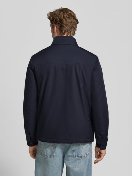 Männermodel trägt Jacke mit verdecktem Reißverschluss und Eingrifftaschen von Geox in Dunkelblau, glatte Textur, Ganzkörperansicht Rückansicht, Regular Fit, Stehkragen, Rückenlänge 71 cm, Schulterbreite 50 cm, Brustweite 58 cm, Ärmellänge 69 cm.