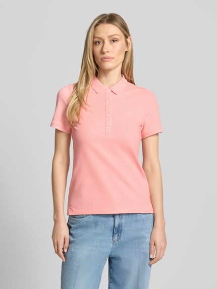 Frauenmodel trägt Slim Fit Poloshirt mit Label-Stitching von Gant aus Baumwoll-Elasthan-Mix, Knopfleiste, Rückenlänge 59 cm, Ganzkörperansicht von vorne.