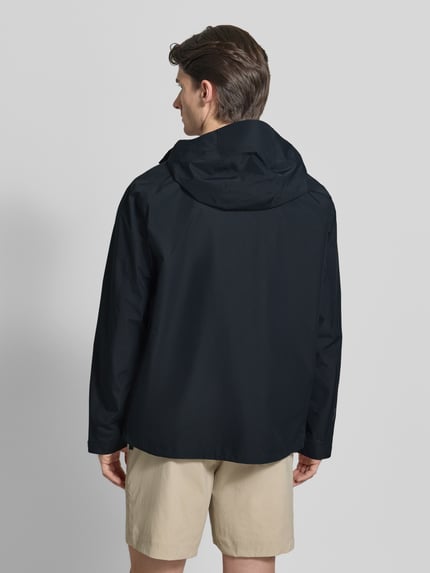 Męski model nosi Regular Fit Jacke mit Logo-Print Modell 'Treeline' von PEAK PERFORMANCE, czarna, kaptur, tył, krój regular fit, długość pleców w rozmiarze M: 73 cm, szerokość ramion w rozmiarze M: 42 cm, szerokość klatki piersiowej w rozmiarze M: 57 cm, długość rękawa w rozmiarze M: 68 cm, widok całej sylwetki z tyłu
