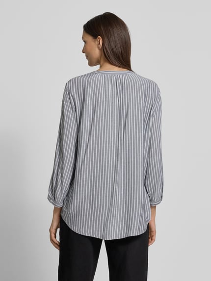 Frauenmodel trägt Comfort Fit Langarmbluse aus reiner Viskose von Tom Tailor mit Allover-Streifendesign, 3/4-Arm, Rückansicht.