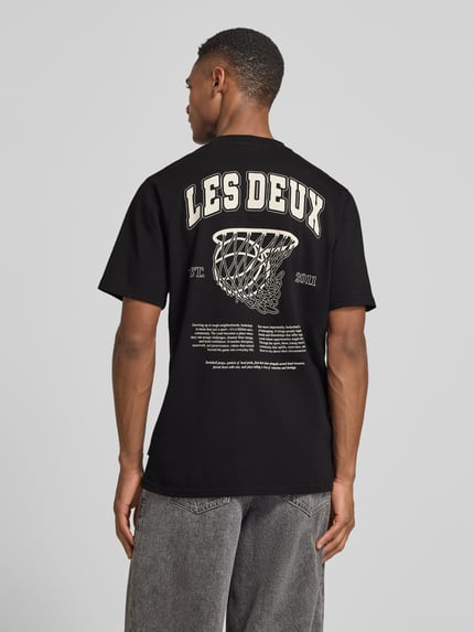 Männermodel trägt Herren T-Shirt mit Label-Print Modell 'Brady whop' von Les Deux, Reine Baumwolle, Gerader-Schnitt, Rückenlänge 72 cm, Ganzkörperansicht Rückansicht