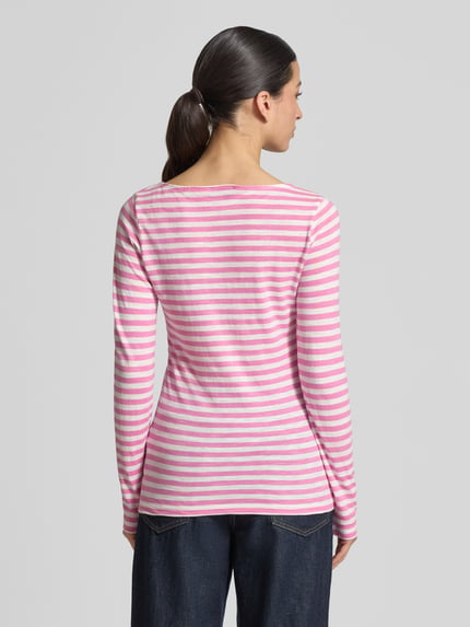 Frauenmodel trägt Regular Fit Langarmshirt aus reiner Baumwolle von Marc O’Polo mit pink-weißem Allover-Streifenmuster, Ganzkörperansicht Rückansicht.