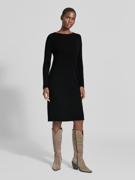 Frauenmodel trägt Slim Fit Kleid aus reinem Kaschmir in Strick-Optik von Christian Berg Woman, knielang, schwarz, glatte Struktur, Ganzkörperansicht von vorne.