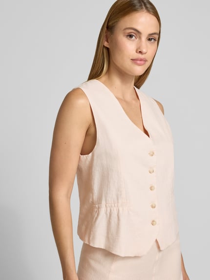 Frauenmodel trägt Leinenweste mit V-Ausschnitt und Paspeltaschen von Emily Van den Bergh in zartem Beige, Regular Fit, Nahaufnahme Oberkörper.