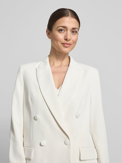 Modelka nosi Regular Fit Blazer mit Pattentaschen von Christian Berg Cocktail, mieszanka materiałów z dodatkiem streczu, dwurzędowy, kołnierz z połami, kieszenie z patką, długość tyłu w rozmiarze 36: 70 cm, jasny kolor, gładka tekstura, zbliżenie na górną część ciała.