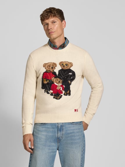 Männermodel trägt Pullover aus Wolle mit Teddy-Motiv von POLO RALPH LAUREN, mehrfarbig, Strickoptik, Regular Fit, Ganzkörperansicht von vorne.