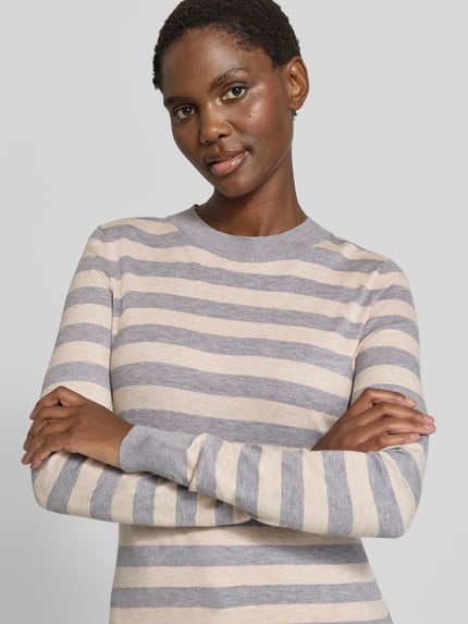 Frauenmodel trägt Strickpullover mit Rundhalsausschnitt von Christian Berg Woman in Grau und Beige mit tailliertem Schnitt, Nahaufnahme Oberkörper.