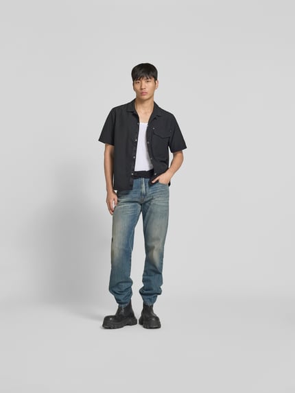 Mannelijk model draagt Freizeithemd mit Brusttasche van Moose Knuckles, regular fit, kentkraag, korte mouwen, zwarte stof, volledige lichaamsaanzicht van voren.