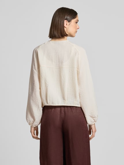 Frauenmodel trägt Blouson aus Viskose-Mix mit Rundhalsausschnitt Modell 'Jarosa' von OPUS in Creme, Loose-Fit, Raglanärmel, Struktur. Ganzkörperansicht Rückansicht. Damen Blouson, Rückenlänge 50 cm, Schulterbreite 47 cm, Brustweite 54 cm, Ärmellänge 60 cm.