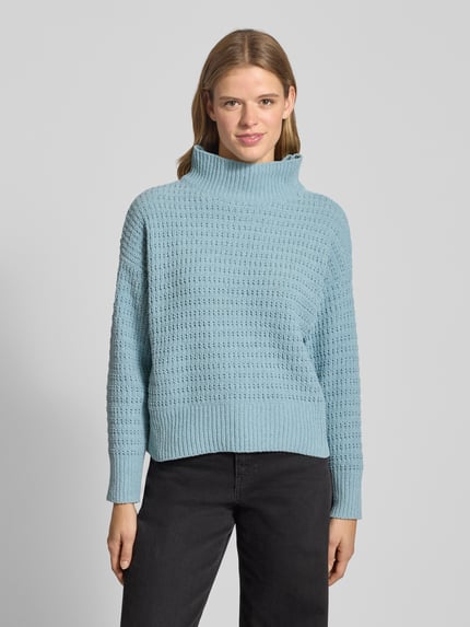 Modelka kobieca nosi Regular Fit Strickpullover mit Mock Neck Kragen Modell 'GLOBE' od Only, jasnoniebieski, dzianinowy, jednolity, długi rękaw, ściągacze, widok na całą sylwetkę z przodu.