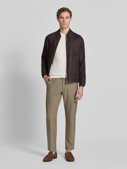 Männermodel trägt Straight Leg Hose mit Viskose-Anteil Modell 'ROBERT' von SELECTED HOMME in Melange-Optik mit seitlichen Eingrifftaschen, Label-Patch, elastischem Bundabschluss mit Tunnelzug, Paspeltaschen; Ganzkörperansicht von vorne.