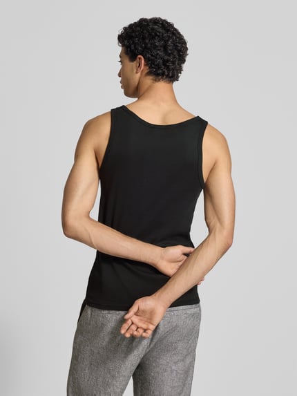 Männermodel trägt Slim Fit Tank Top aus reiner Baumwolle im 2er-Pack von Tommy Jeans, jednokolorowy, krój slim fit, wyhaftowane logo, dekolt w łódkę, wykończenie: drobne prążkowanie, materiał: bawełna, Ganzkörperansicht Rückansicht.
