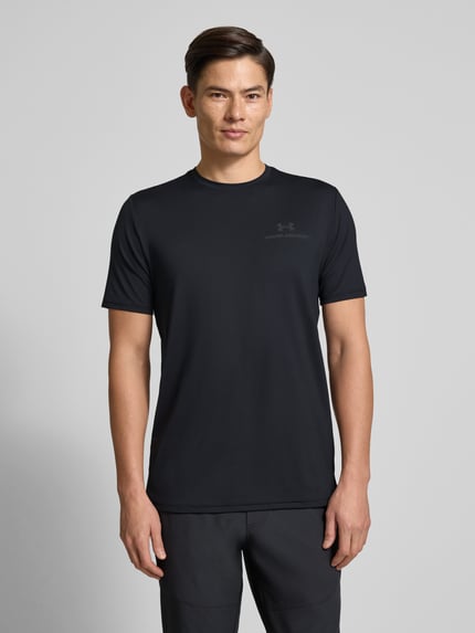 Männermodel trägt T-Shirt mit Logo Modell 'Vanish Energy' von Under Armour, schwarzer Material-Mix mit Stretch-Anteil, Regular-Fit, Rundhalsausschnitt, Rückenlänge 75 cm, Ganzkörperansicht von vorne.