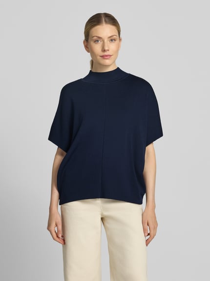 Kobieta nosi Strickshirt aus Viskose-Mix mit 3/4-Arm od MORE & MORE, granatowy kolor, luźny krój, stójka, widoczna faktura dzianiny, długość pleców 58 cm, długość rękawa 23 cm, Ganzkörperansicht von vorne.