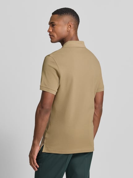 Männermodel trägt Regular Fit Poloshirt aus reiner Baumwolle von Barbour, Optik: Unifarben, Piqué, Ganzkörperansicht Rückansicht.