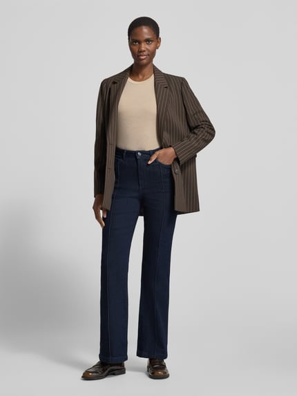 Frauenmodel trägt Regular Fit Bootcut Jeans mit Teilungsnähten von S.OLIVER CASUAL in Dark Wash Denim mit 5-Pocket-Design, Ganzkörperansicht von vorne.
