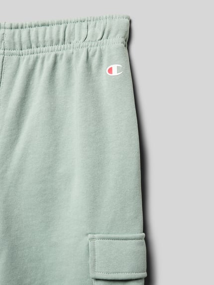Produktfoto, Bermudas aus Baumwoll-Mix mit Label-Detail von CHAMPION in Hellgrün, gerade Passform, elastischer Bund, Cargotasche, Detailaufnahme