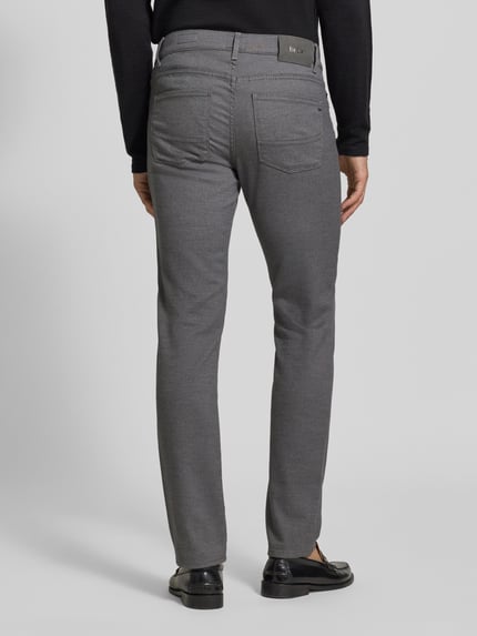 Männermodel trägt Stoffhose aus Baumwoll-Mix mit Viskose-Anteil Modell 'Cadiz' von Brax in Melange Grau, Straight Fit, Ganzkörperansicht Rückansicht.