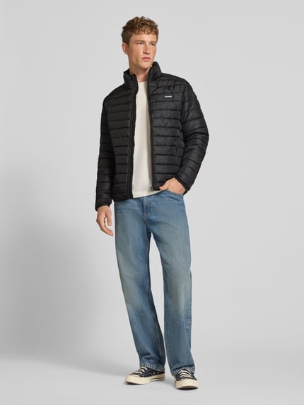 Männermodel trägt schwarze Jacke mit Label-Patch Modell 'ELVIS' von JACK & JONES, gerader Schnitt, Ganzkörperansicht von vorne.