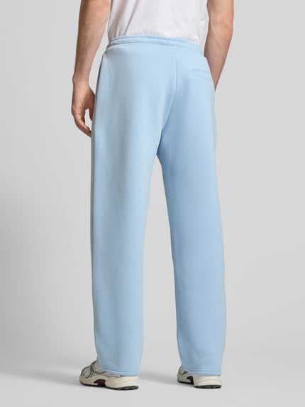 Männermodel trägt Sweatpants aus Baumwoll-Mix von REVIEW in Hellblau mit Gerader-Schnitt, Elastischer-Bund, Seitentaschen, Label-Detail, Ganzkörperansicht Rückansicht.