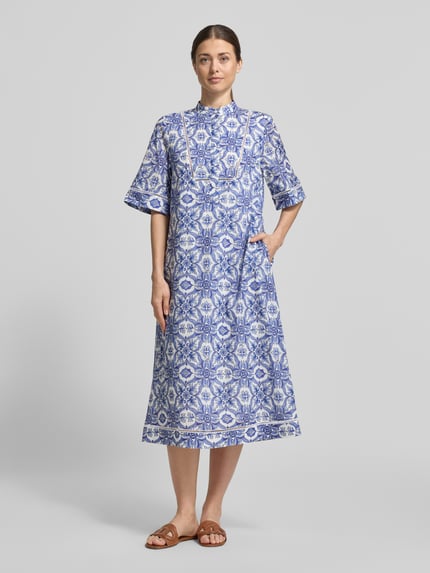 Frauenmodel trägt Midikleid mit verdeckter Knopfleiste Modell 'Desa' von JOOP! in Blau-Weiß mit Allover-Muster aus reiner Baumwolle, gerader Schnitt, Stehkragen, Halbarm, Ganzkörperansicht von vorne.
