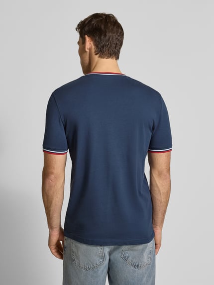 Männermodel trägt T-Shirt mit Kontraststreifen und Rundhalsausschnitt von Christian Berg Men aus Baumwoll-Elasthan-Mix, Regular-Fit, Rückenlänge 71 cm in Größe M, dunkelblau mit roten und weißen Streifen, Ganzkörperansicht Rückansicht.