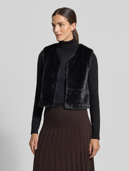 Vrouwenmodel draagt Regular Fit bodywarmer van imitatiebont in effen design van ZABAIONE, ruglengte 48 cm, schouderbreedte 36 cm, borstwijdte 48 cm, mouwloos design, effen kleuren, geheelaanzicht van voren.