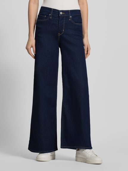 Frauenmodel trägt Wide Fit Jeans mit 5-Pocket-Design von Levi's®, dunkler Baumwoll-Mix mit Stretch-Anteil, lockerer Schnitt, Knopf- und Reißverschluss, Ganzkörperansicht von vorne.