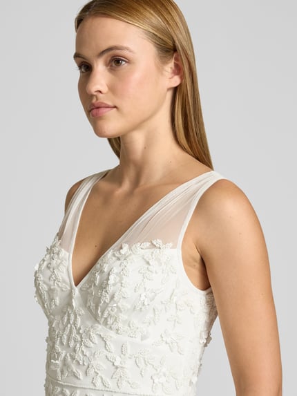 Frauenmodel trägt Maxikleid mit Perlen und V-Ausschnitt von Adrianna Papell aus Mesh in Creme, Allover-Look, Nahaufnahme Oberkörper. Rückenlänge bei Größe 36: 132 cm, Brustweite bei Größe 36: 37 cm.