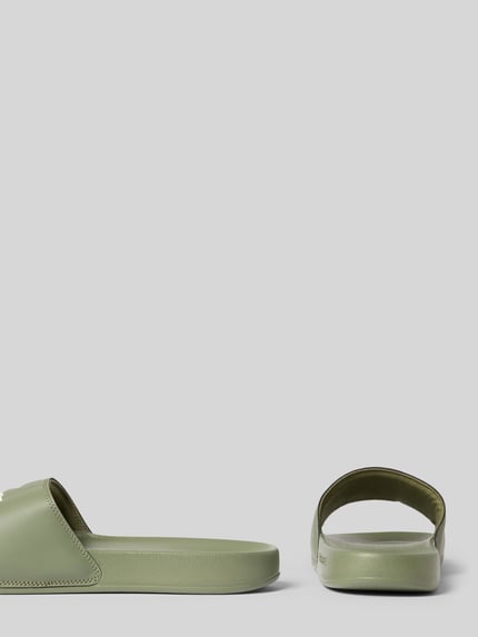 Produktfoto, Badeschuhe mit Logo-Print Modell 'SERVE SLIDE 0.0' von Lacoste, zielona barwa, zaokrąglony przód, płaski obcas, strukturalna podeszwa, jednolita kolorystyka, wsuwane, męskie