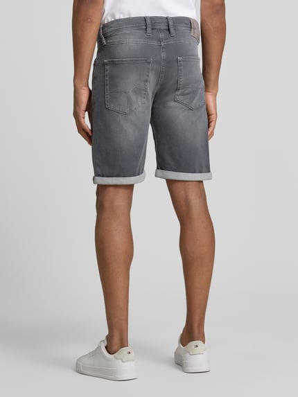 Männermodel trägt Bermudas in Denim-Optik von MAC in Grau mit Used-Look, Eingrifftaschen und Umschlag, Ganzkörperansicht Rückansicht.
