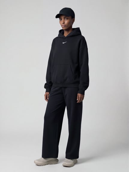 Männermodel trägt Oversized Fit Hoodie aus reiner Baumwolle von Nike in Schwarz, strukturierte Optik, Logo-Detail, Ganzkörperansicht von vorne.