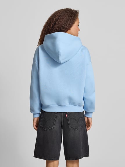 Vrouwenmodel draagt Relaxed Fit Sweatjacke mit Kapuze van REVIEW in lichtblauw katoen met logo-print en kangoeroezakken, rugaanzicht.