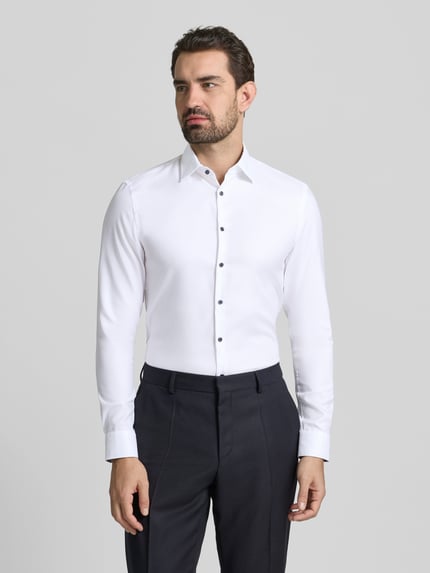 Männermodel trägt weißes Super Slim Fit Business Hemd aus Baumwolle mit Kentkragen von Jake*s, Ganzkörperansicht von vorne.