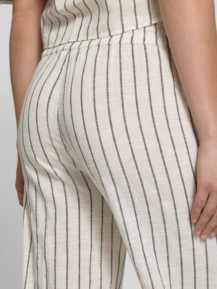 Frauenmodel trägt Losse Fit Stoffhose aus reiner Baumwolle Modell 'TIZIANA' von Only mit gestreiftem Allover-Muster, elastischem Bund und seitlichen Eingrifftaschen, helle Farben, feine Linienstruktur, Nahaufnahme Hüfte und Oberschenkel, Detailaufnahme.
