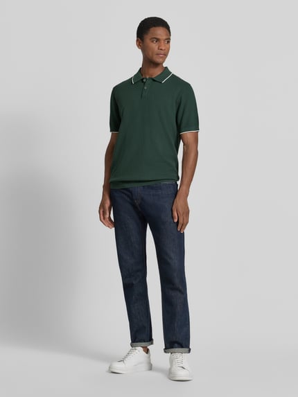 Mannelijk model draagt Regular Fit poloshirt met contrastkante van Christian Berg Men, puur katoen, structuurpatroon, polokraag, korte knoopsluiting, donker groen met witte accenten, heren poloshirt, ruglengte maat M 67 cm, mouwlengte 30 cm, ganzekörperaanzicht van voren.