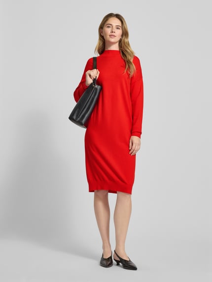Kobiece model prezentuje Knielanges Kleid mit Rundhalsausschnitt od Christian Berg Woman, mieszanka wiskozy, taliowany krój, długość do kolan, okrągły dekolt, prążkowane wykończenia, tył 103 cm, szerokość klatki piersiowej 52 cm, długość rękawa 53 cm, intensywnie czerwony kolor, gładka tekstura, całkowity widok z przodu.