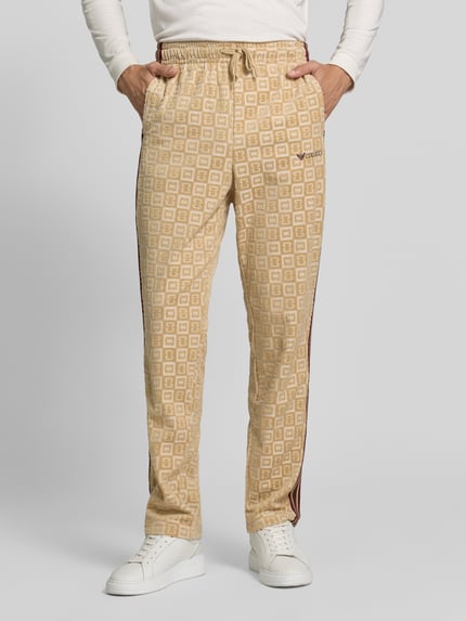 Männermodel trägt Straight Fit Sweatpants mit Label-Stitching von COLUCCI, beigefarben mit Muster, Baumwoll-Mix, Ganzkörperansicht von vorne.