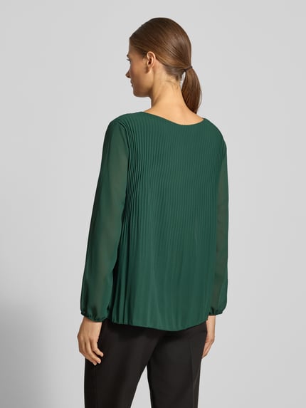 Frauenmodel trägt Langarmbluse aus Viskose-Mix Modell 'Eva' von ZABAIONE in Dunkelgrün mit Biesen und semitransparentem Design, Ganzkörperansicht Rückansicht.