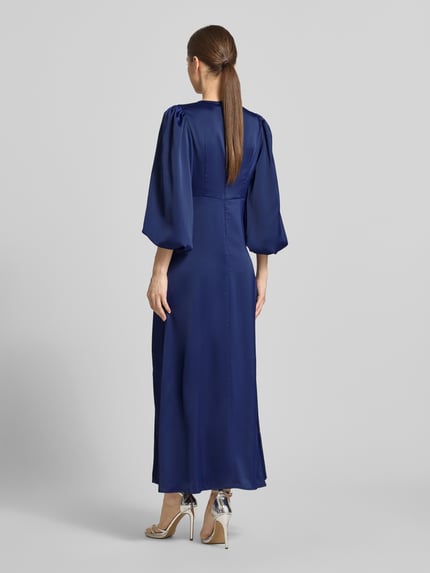 Frauenmodel trägt Damen Maxikleid mit Ballonärmeln, Material-Mix mit Stretch-Anteil, taillierter Schnitt, Modell 'THEA' von YAS, Ganzkörperansicht Rückansicht.