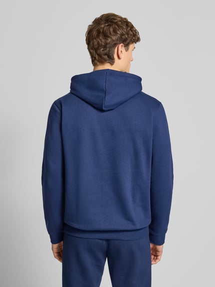 Männermodel trägt Hoodie mit Kapuze von adidas Originals in Blau, lockerer fit, Baumwoll-Mix, Rückansicht Ganzkörperansicht.