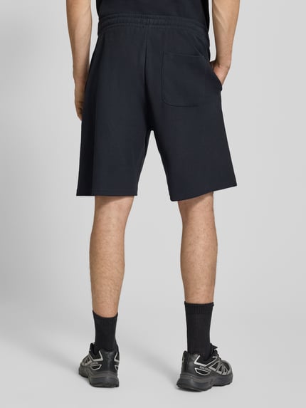 Männermodel trägt Straight Fit Sweatshorts mit Strukturmuster von REVIEW in Schwarz, Reine Baumwolle, Elastischer Bund, Ganzkörperansicht Rückansicht.